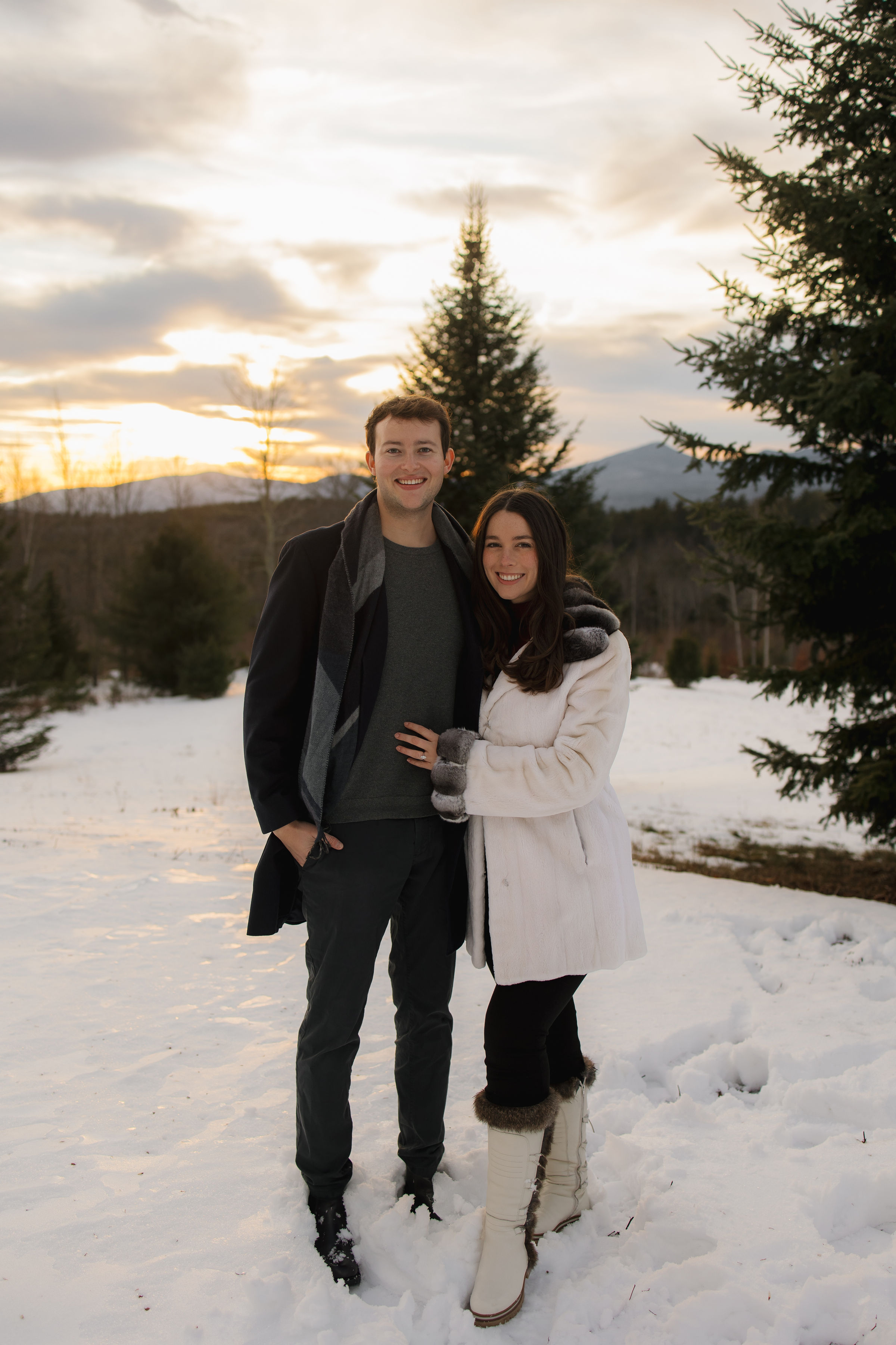 A couple embraces lovingly on a wooden dock.
