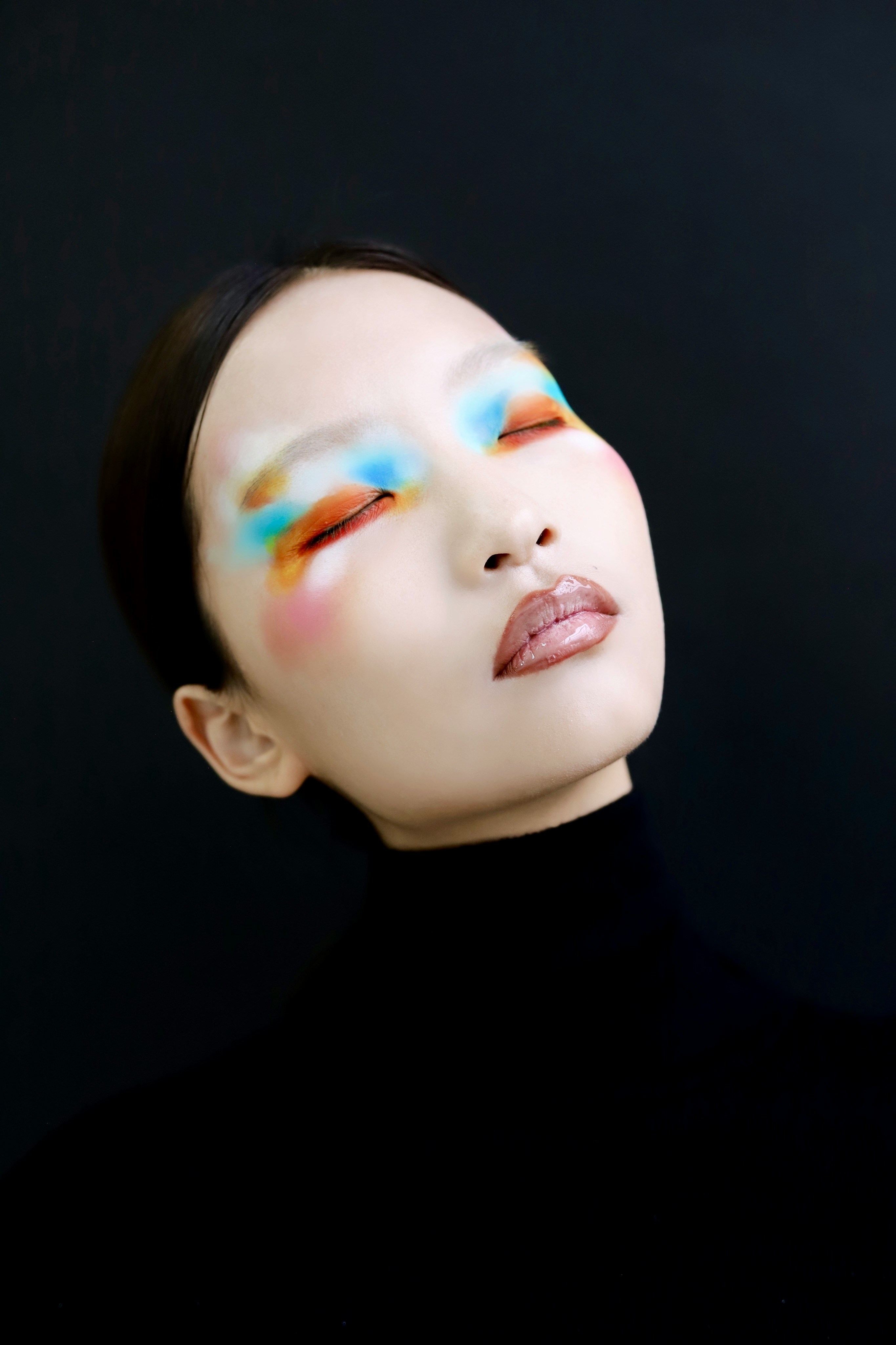 Woman with colorful abstract eye makeup and black turtleneck