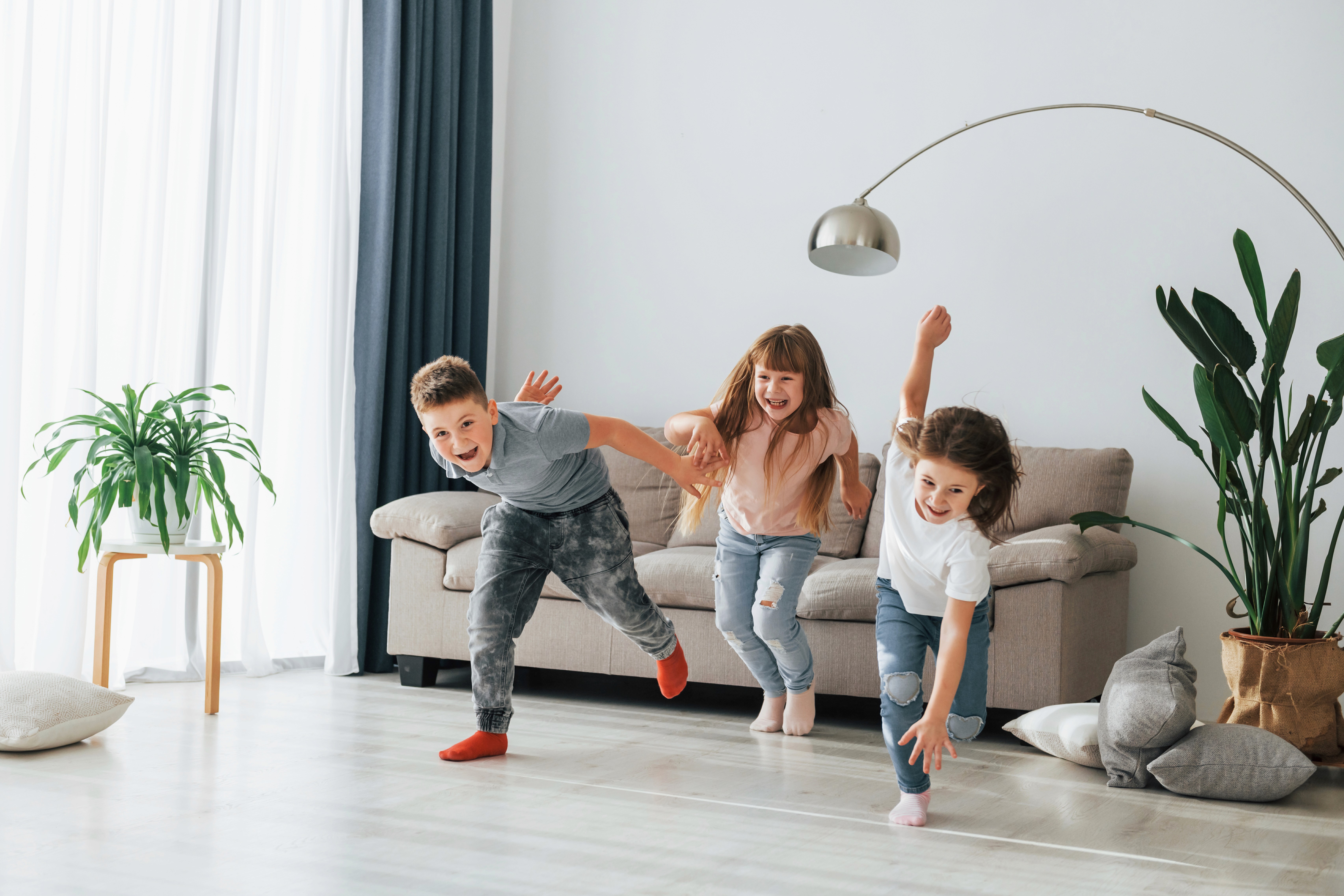 Children run and play freely on LUXO’s light wood-look hybrid flooring, showcasing a durable, slip-resistant, and kid-friendly surface designed for active Australian family homes.