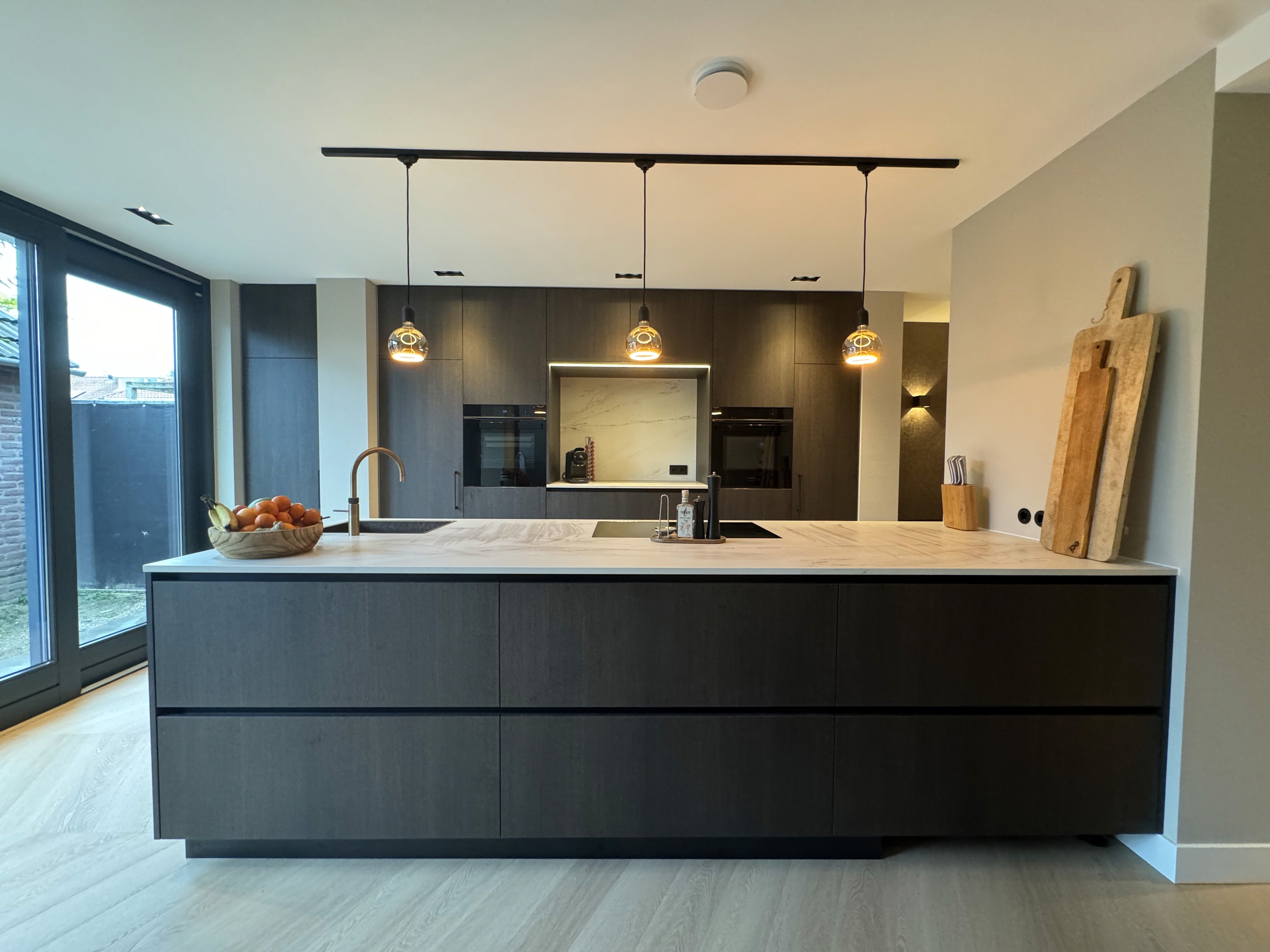 Modene keuken met prachtig afgewerkte eilandkeuken met fineerfronten en stijlvol marmer keukenblad