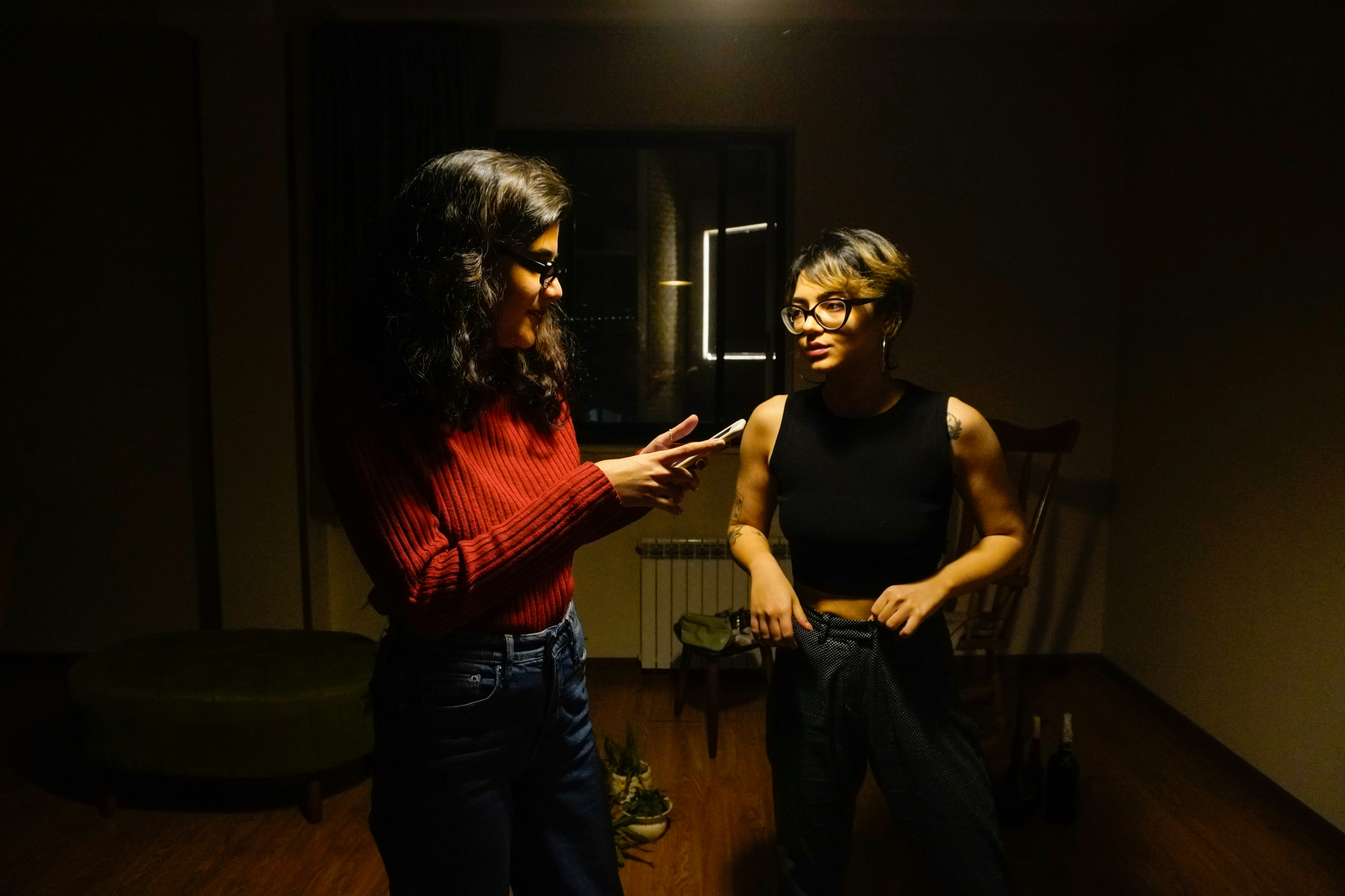 Two young women chatting indoors.