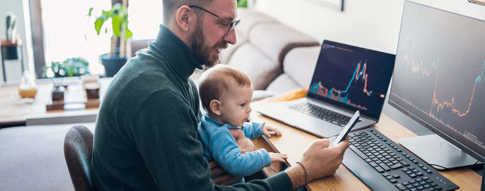 Man trading stocks while holding baby - What Does Onchain Mean in Crypto