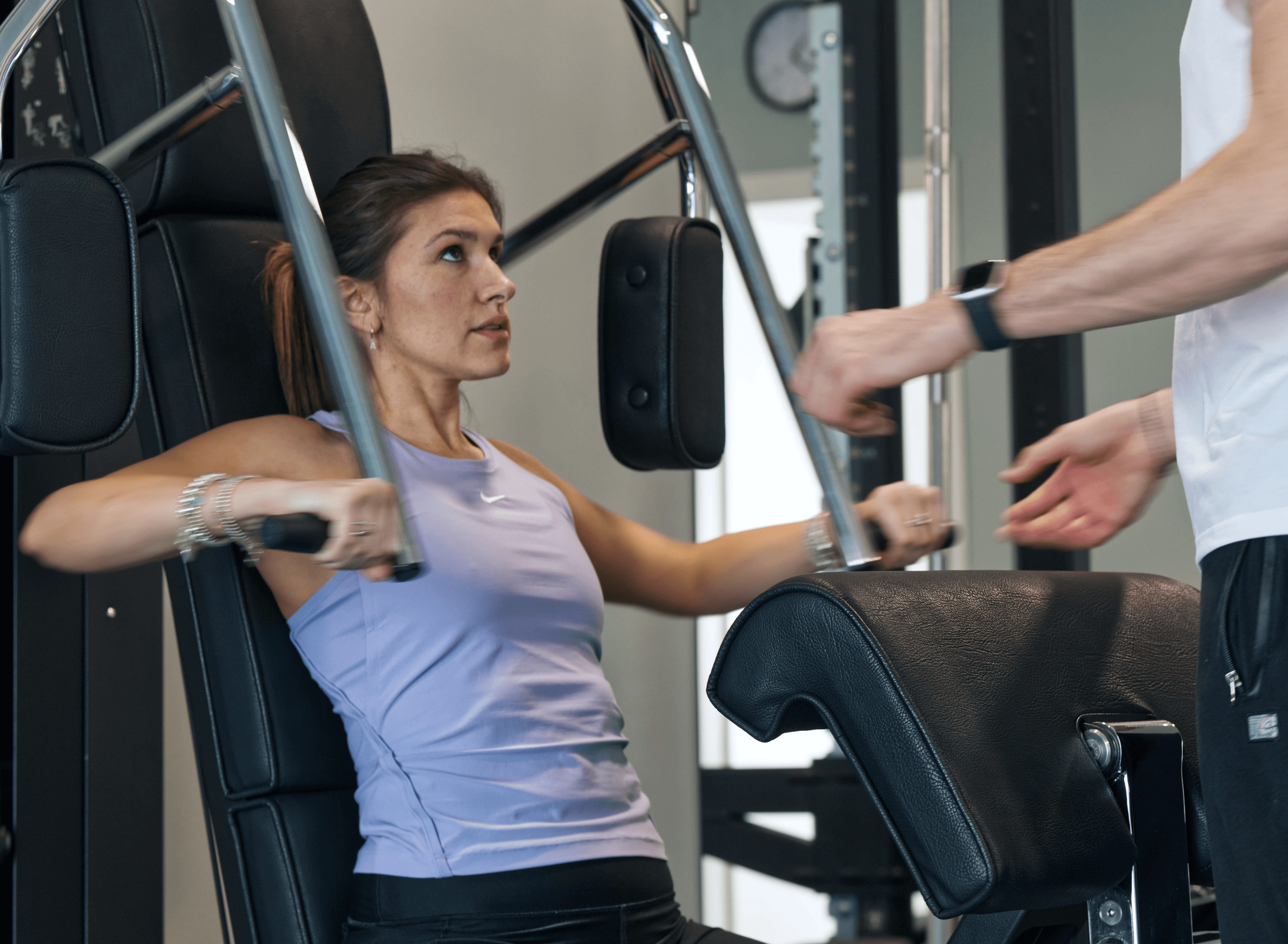 Young person with short, tousled blonde hair wearing an oversized, vibrant orange turtleneck sweater against a soft grey background, conveying a cool, modern look.