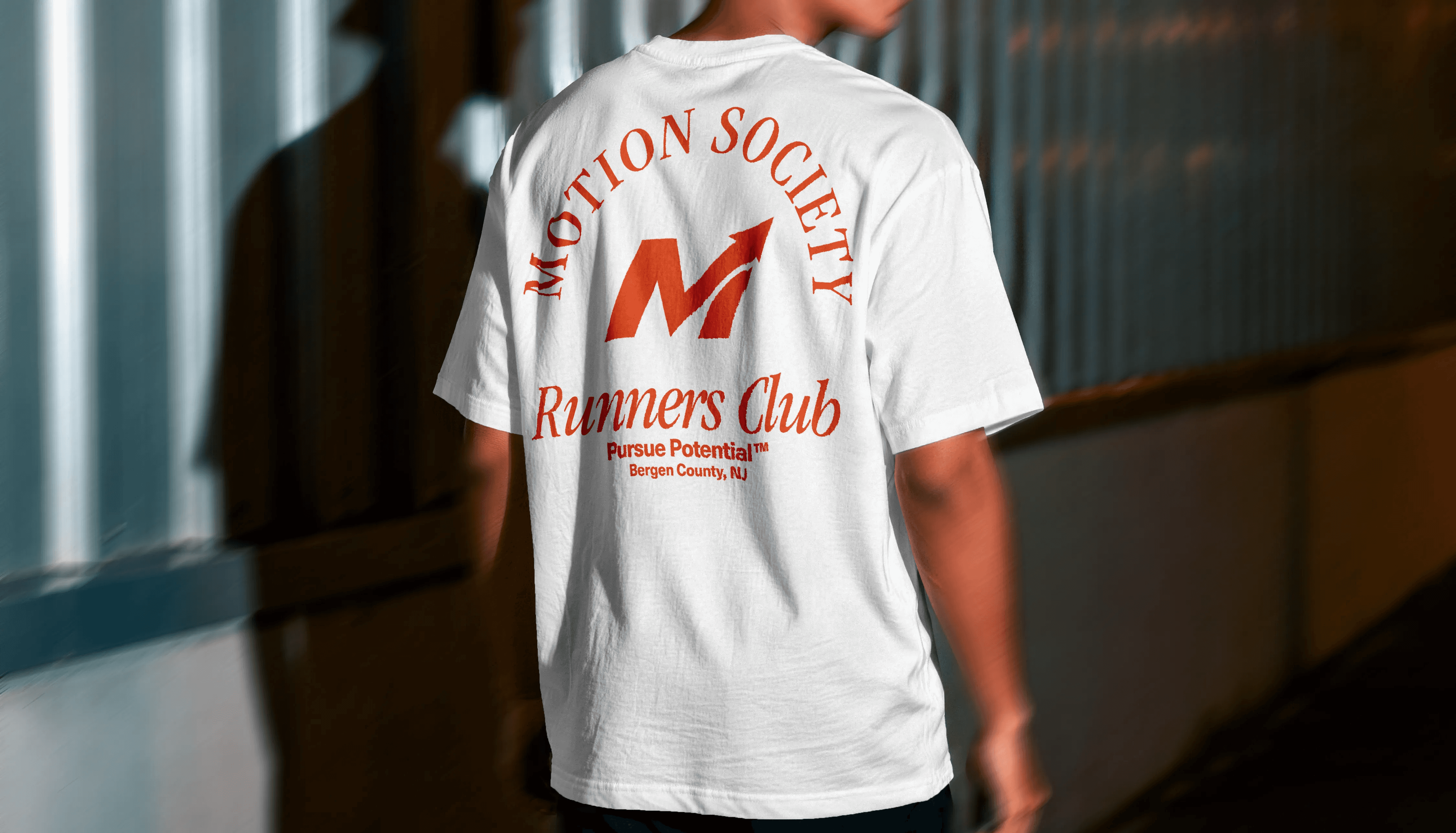White Motion Society Runners Club t-shirt, back print with M-arrow badge design.