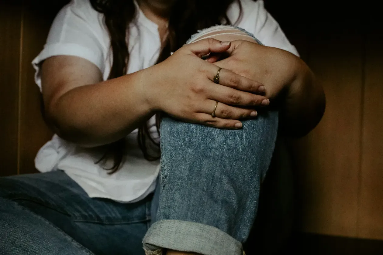 a woman sitting on the floor with her hands on her knees