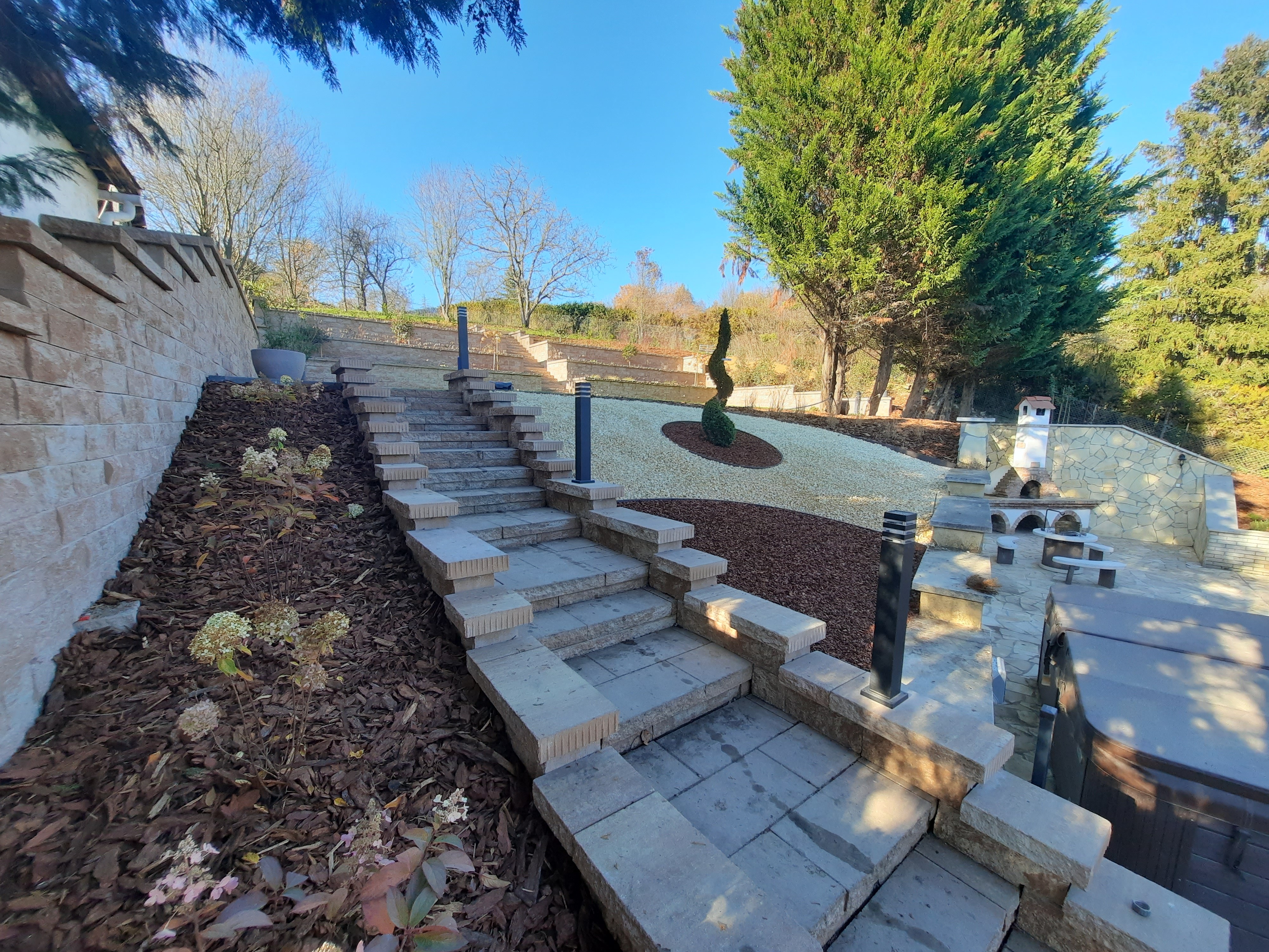 Kertlépcsők kialakítása kőburkolattal és dísznövényekkel