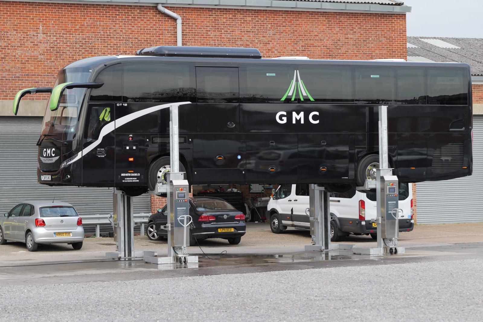Green Metro Coaches GMC coach raised on workshop lifts.