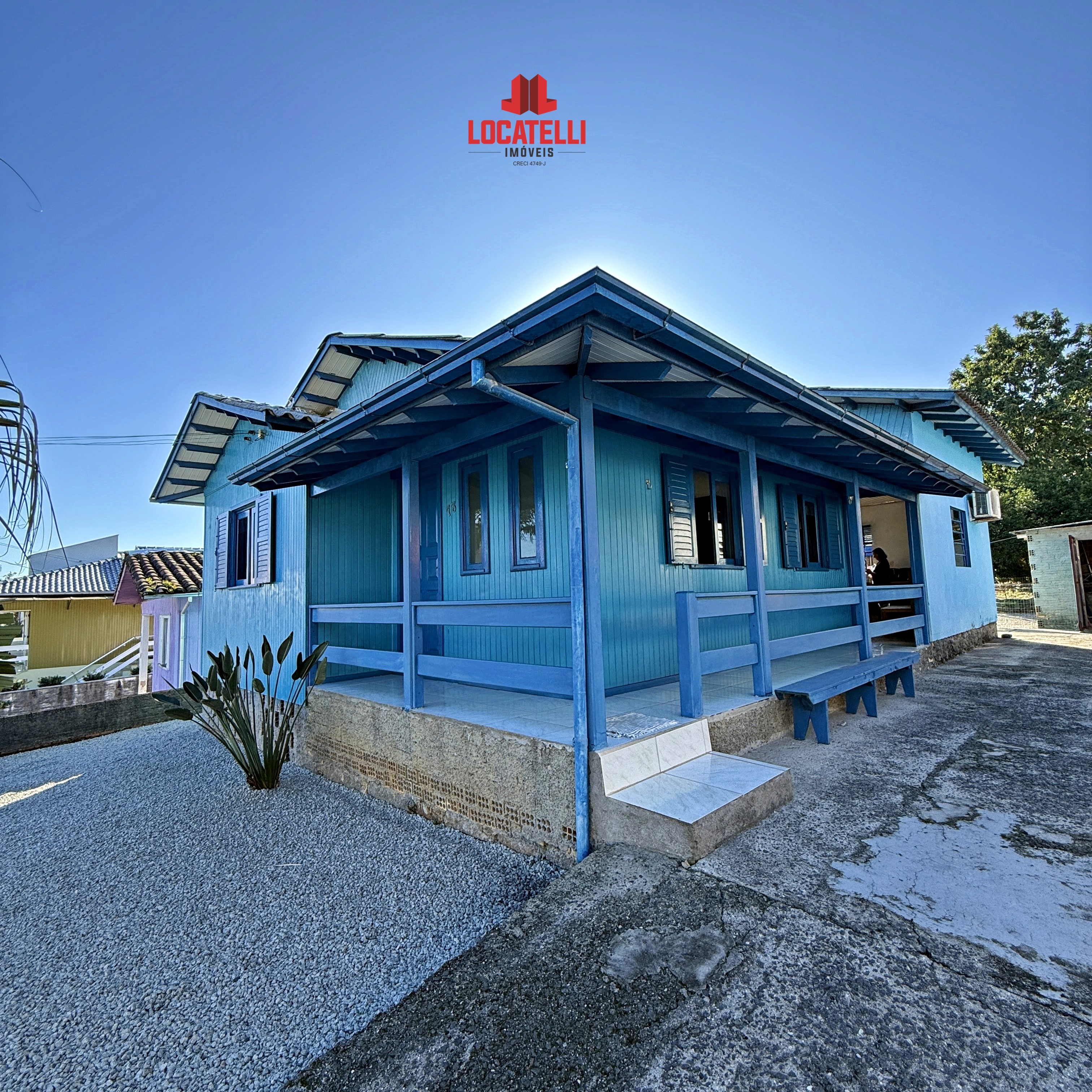 A modern brick house with a two-car garage, well-manicured lawn, and clear blue sky in the background.