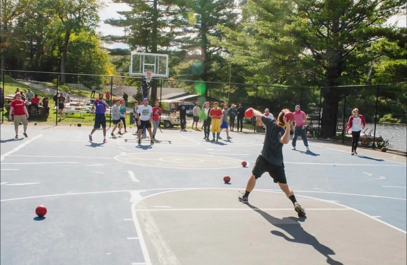 Group playing dodgeball on the outdoor court at Camp Lenox