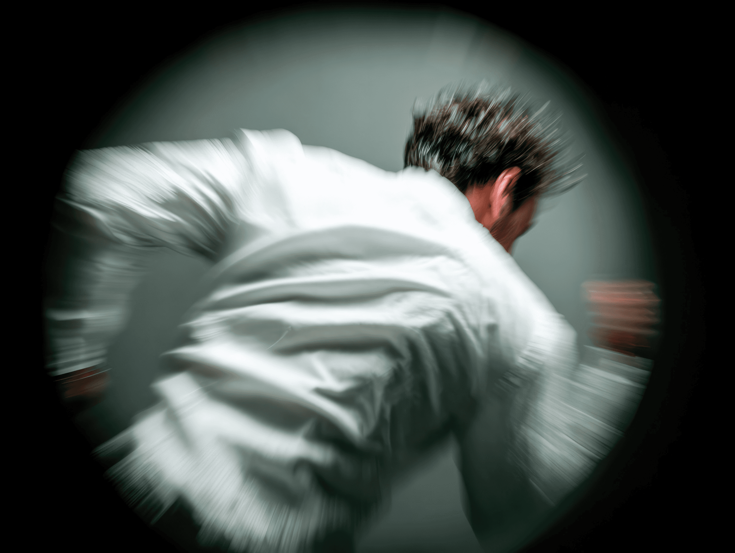 Athlete in white outerwear turning away, captured from the back in motion