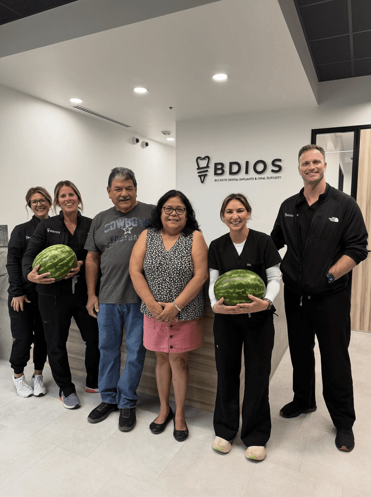 BDIOS Dental team standing in front of reception signage