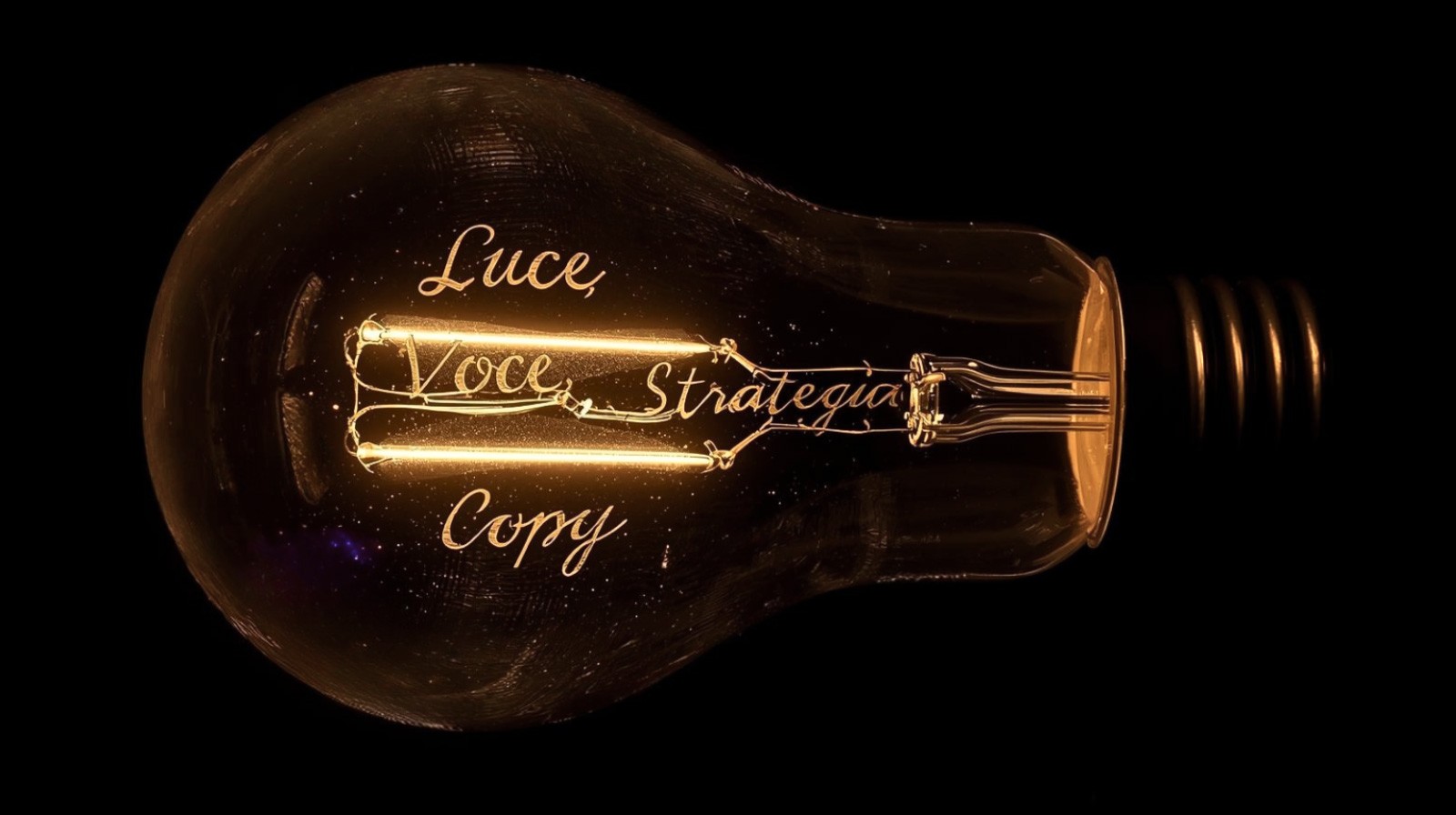 Lampadina vintage su sfondo nero con filamenti luminosi che formano le parole voce, luce e strategia.