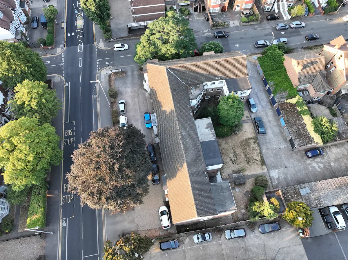 High-altitude drone survey overview of an entire residential complex, mapping building layout, roads, and surrounding trees
