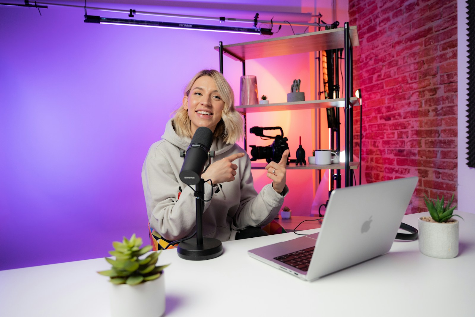 Creatorin mit Mikrofon und Laptop in einem Studio