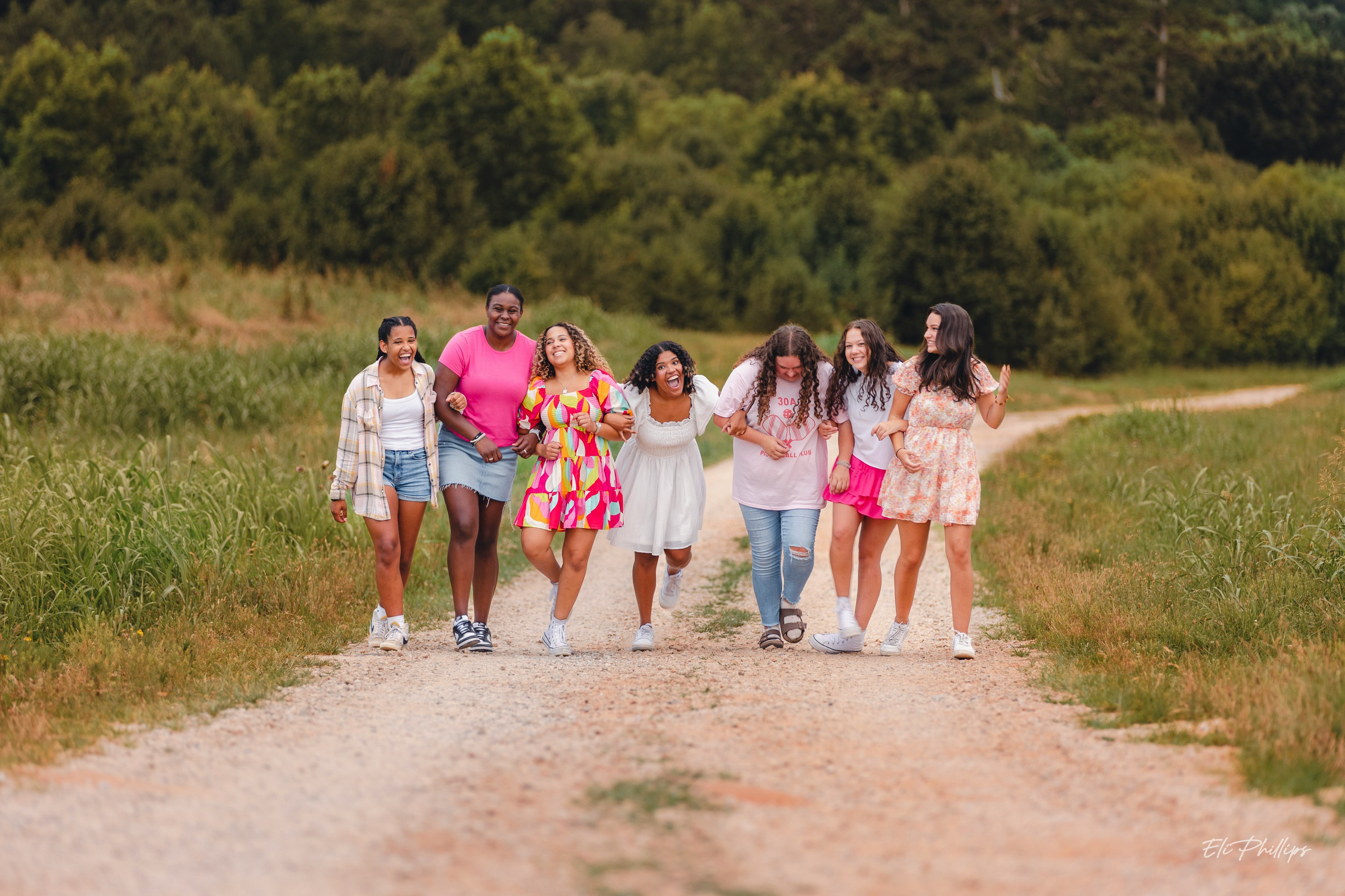 a group of people walking down a dirt road