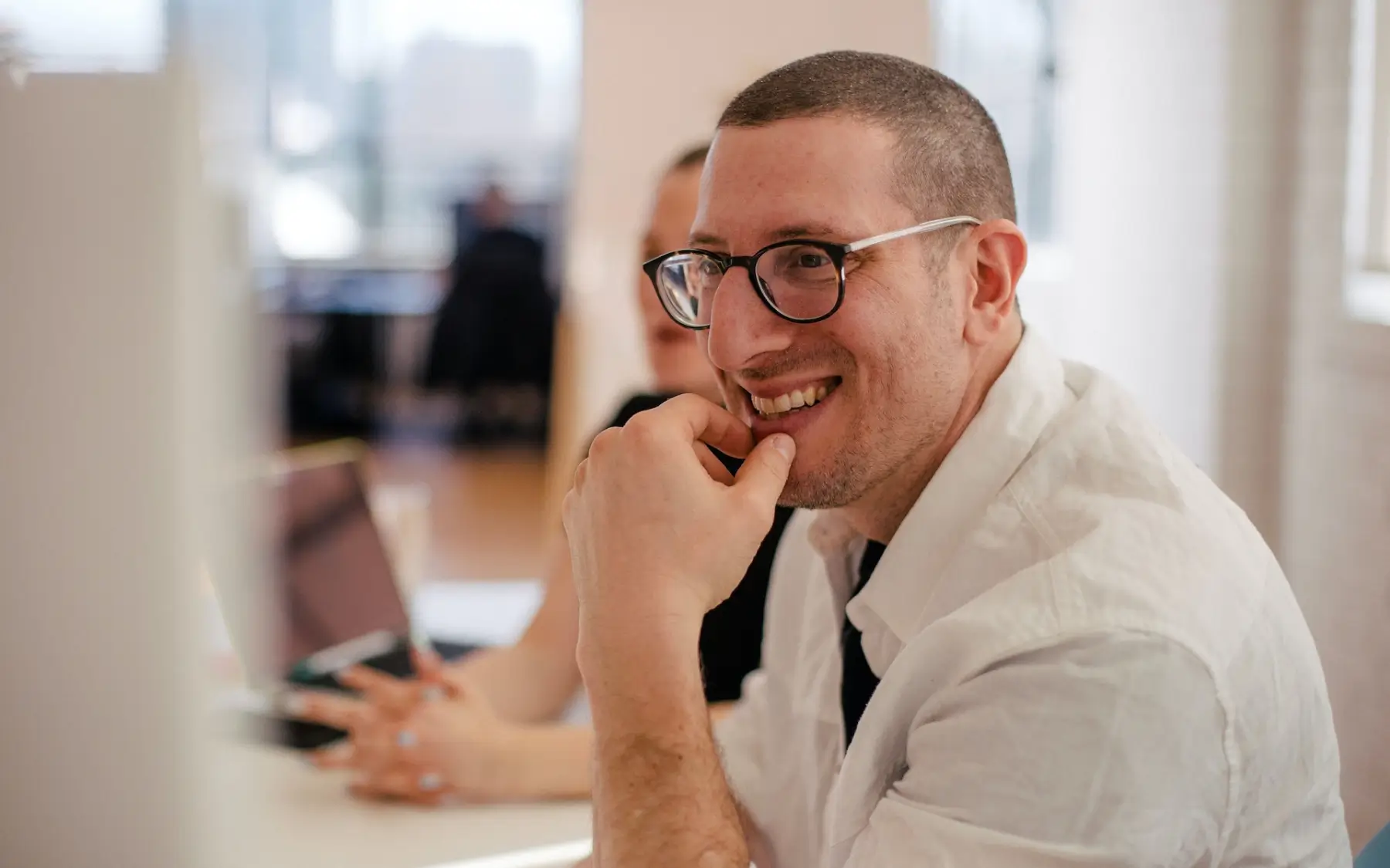 Photograph of a man wearing spectacles looking at a computer screen