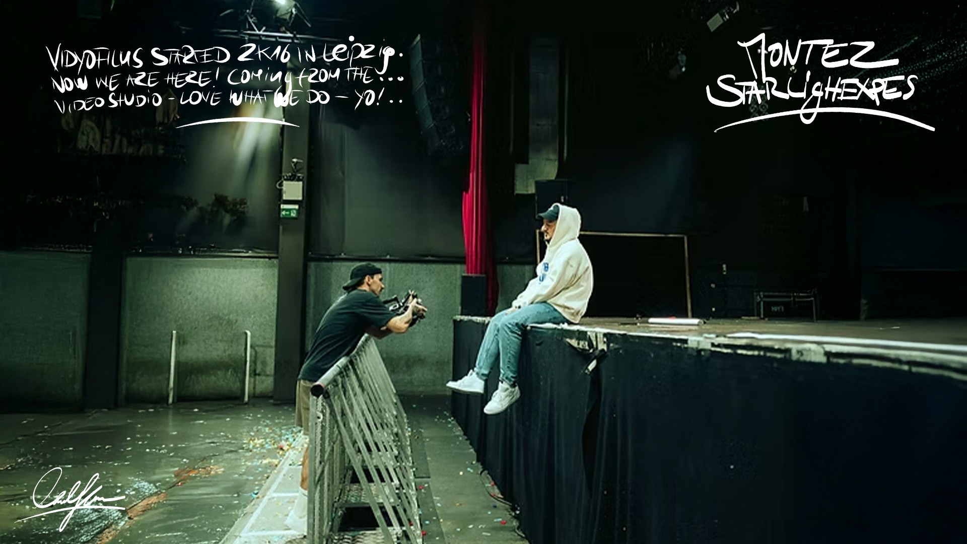 montez singer on stage with camera man, videographer with red 