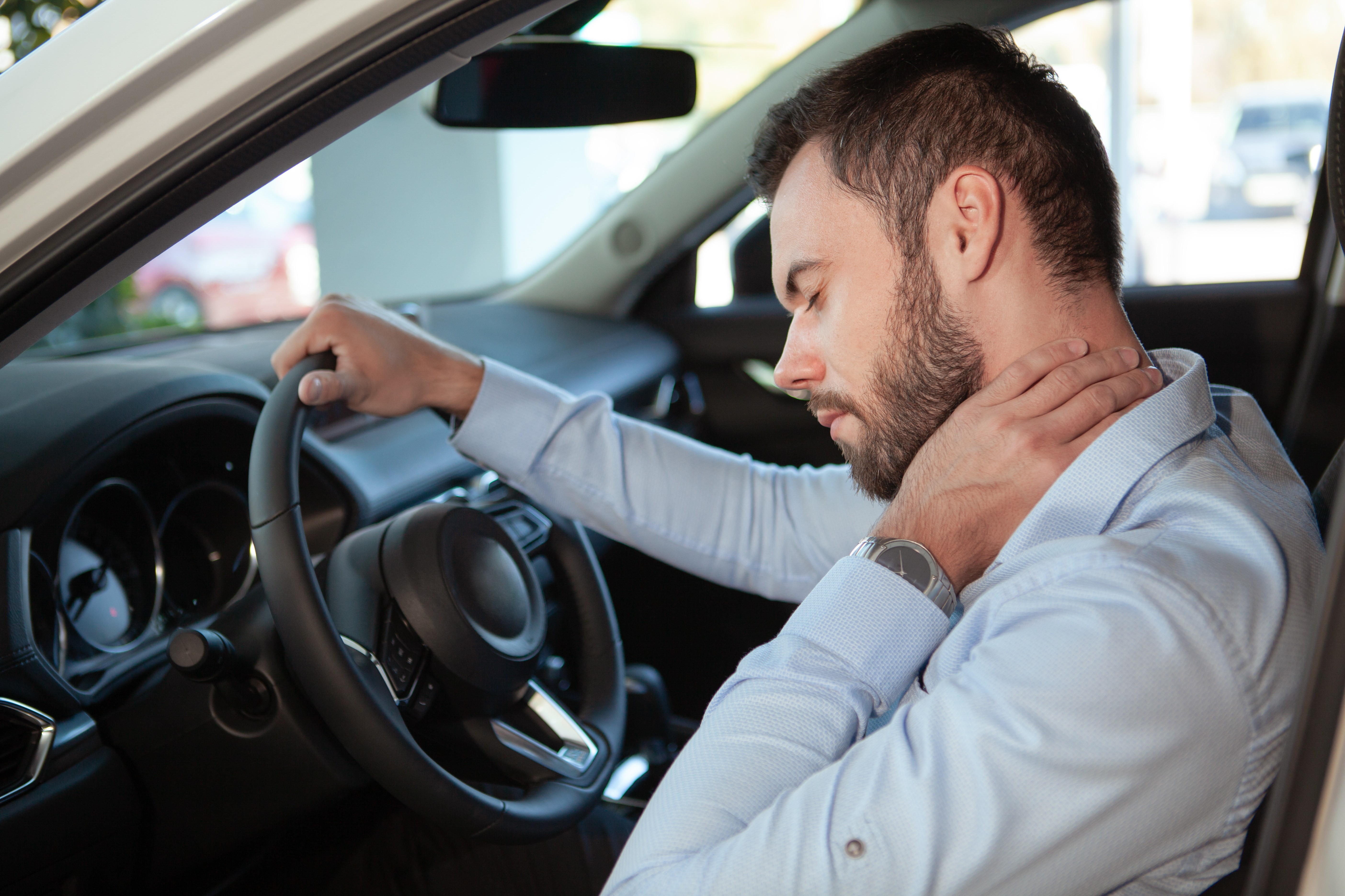male holding neck after a car accident