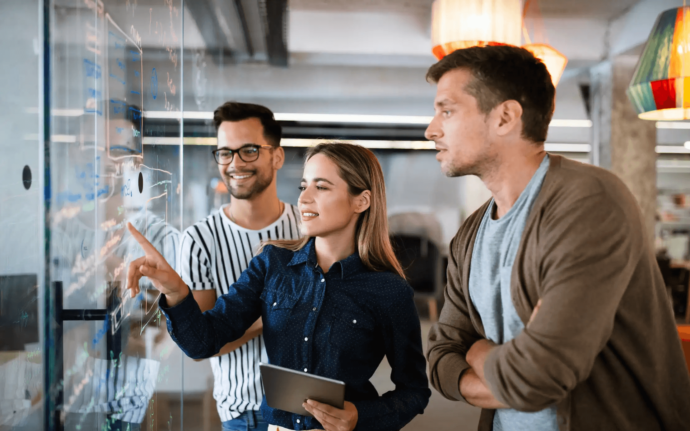 Team analysiert Daten auf digitalem Bildschirm im modernen Büro