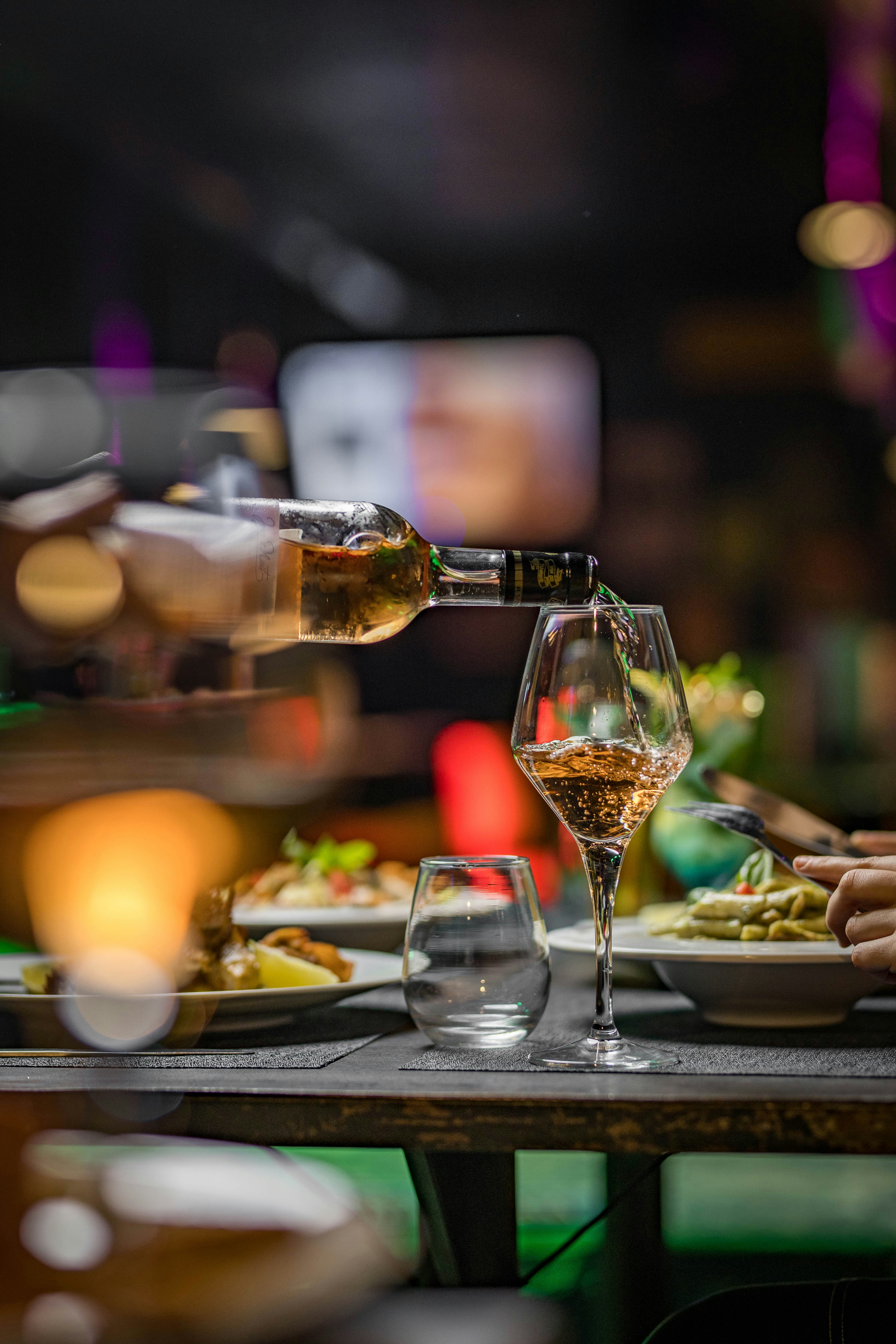 A person pouring wine into a wine glass