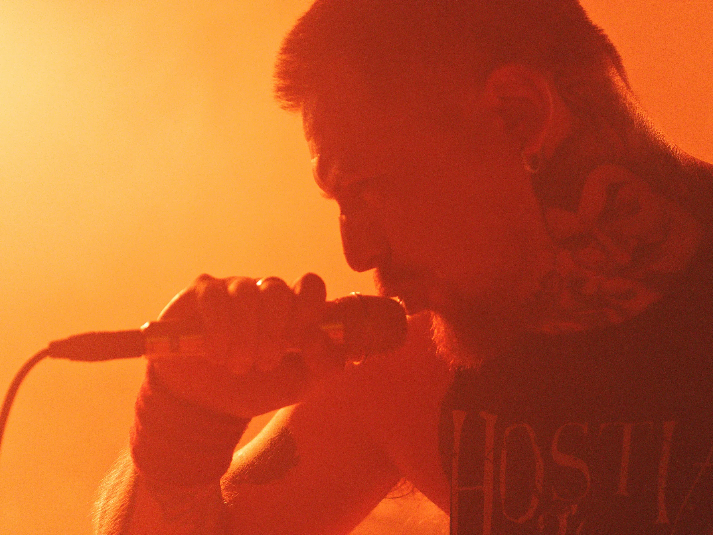 Chanteur de Hostia sur fond Orange