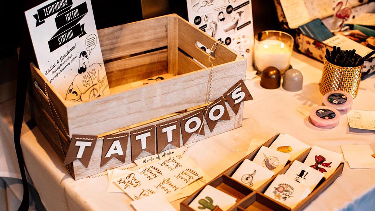 Temporary tattoo station for weddings with custom gold foil and floral designs