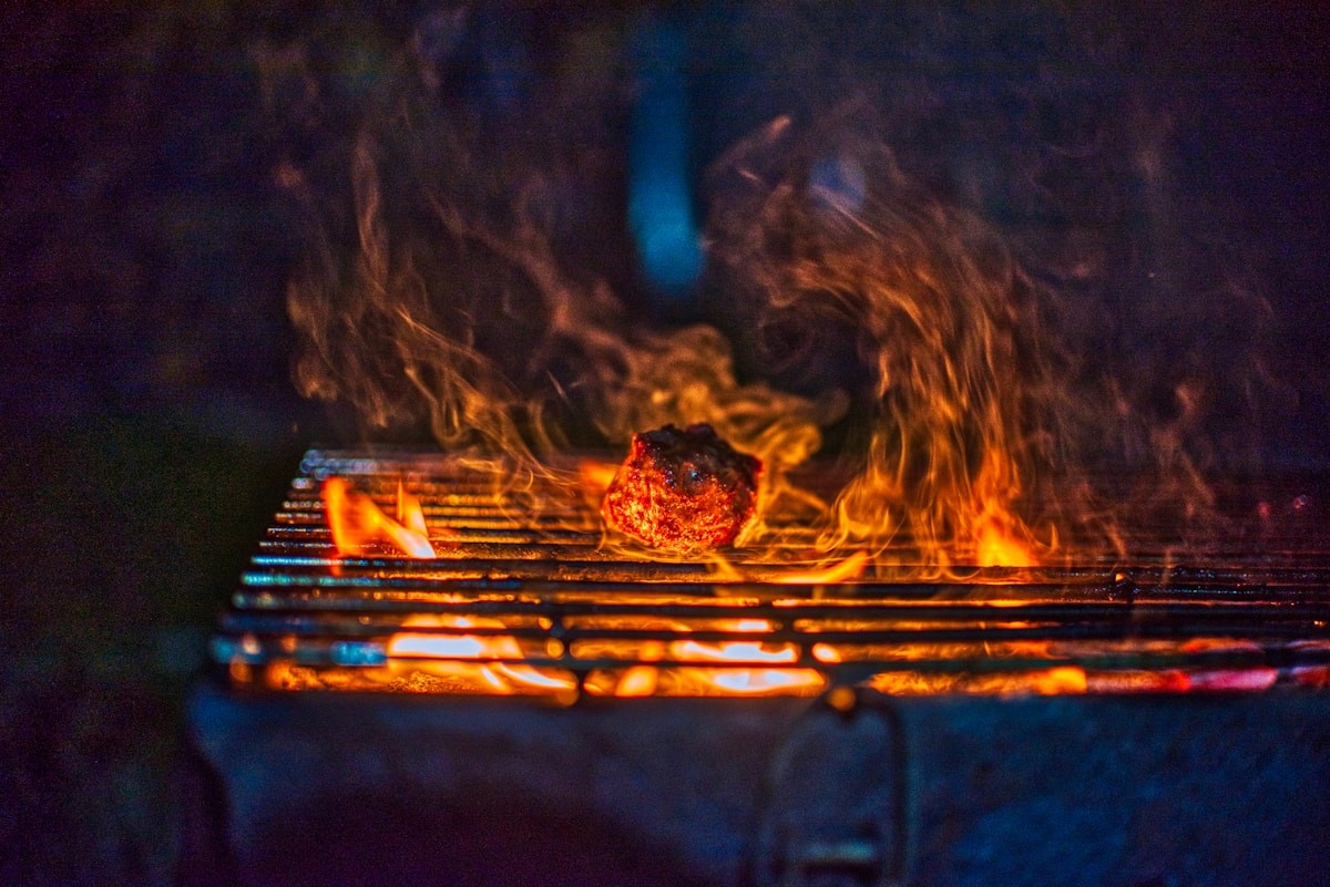 Fire over a charcoal grill in a warm barbecue setting