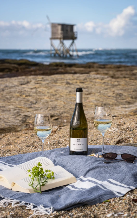 Bouteille de vin blanc posée sur la côte, face à une pêcherie