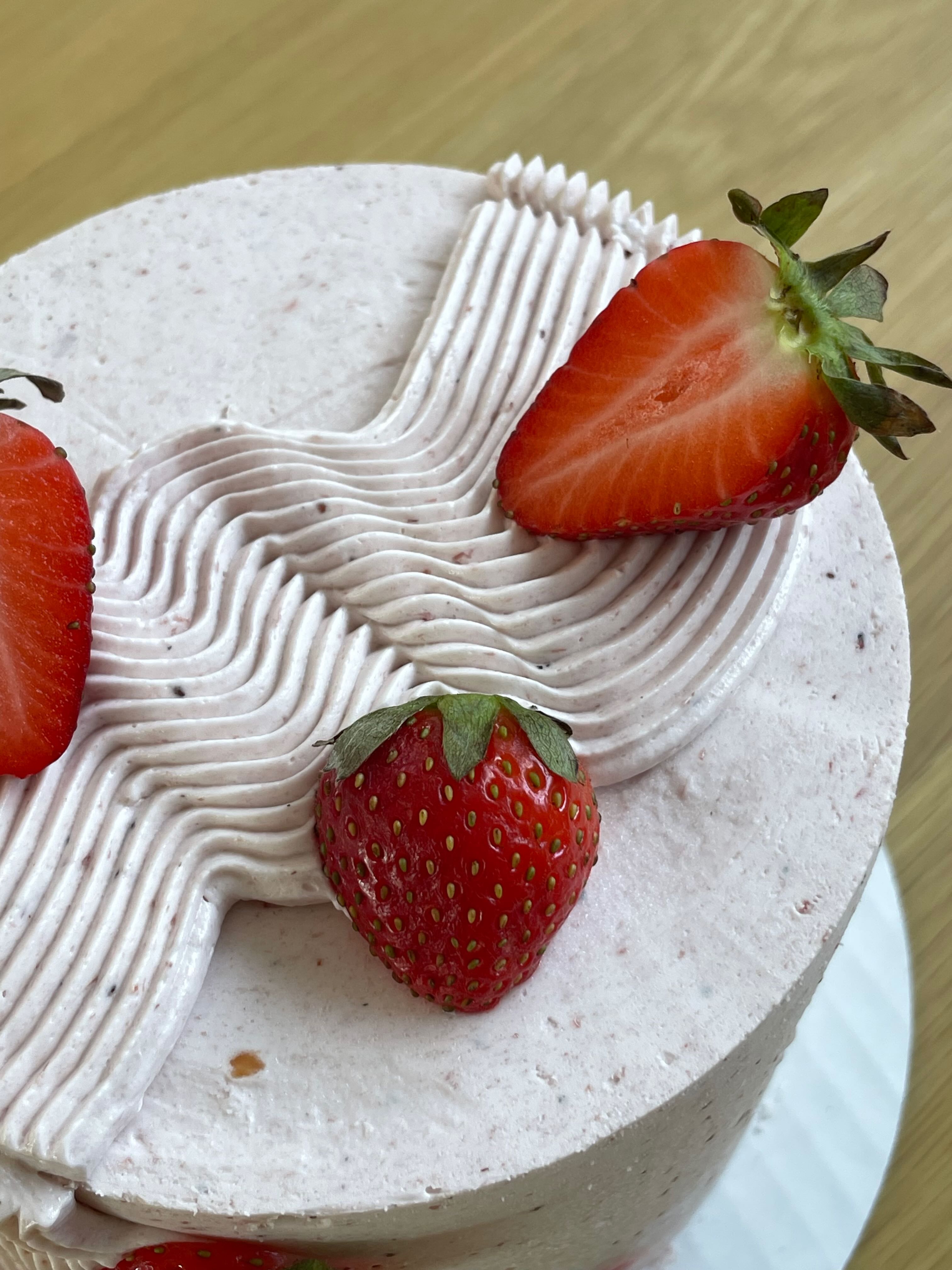 Restaurant interior with wooden tables and chairs lined against a textured wall, softly lit by round wall lamps.