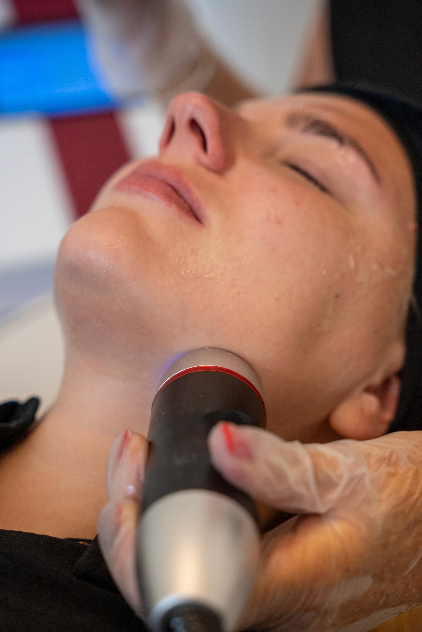 Facial treatment with a device on a woman's chin