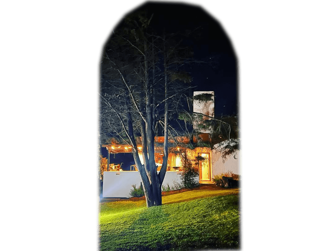 A woman sits cross-legged with eyes closed, wearing a white blouse and a long purple skirt, looking serene.