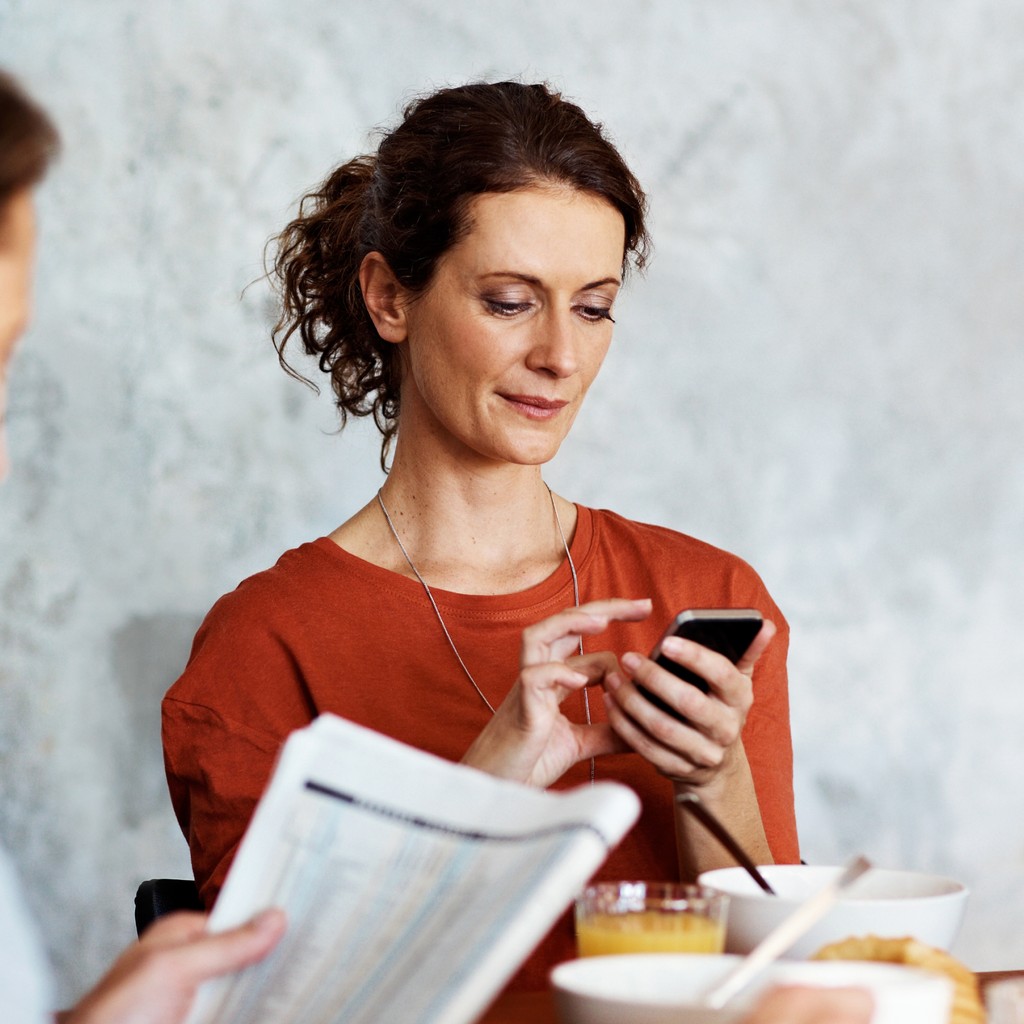 Woman receiving notification at kitchen table