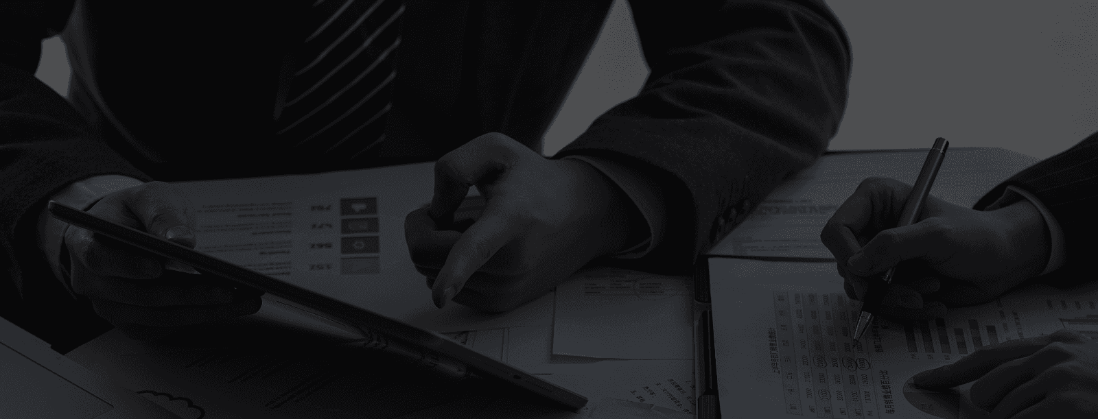 Aerial view of a city at sunset with buildings, bridges, and a river running through the center.