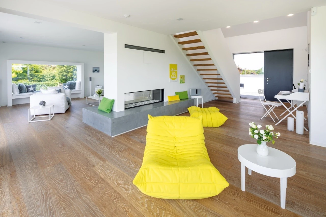 Modern living room with yellow bean bag chairs and a white table.