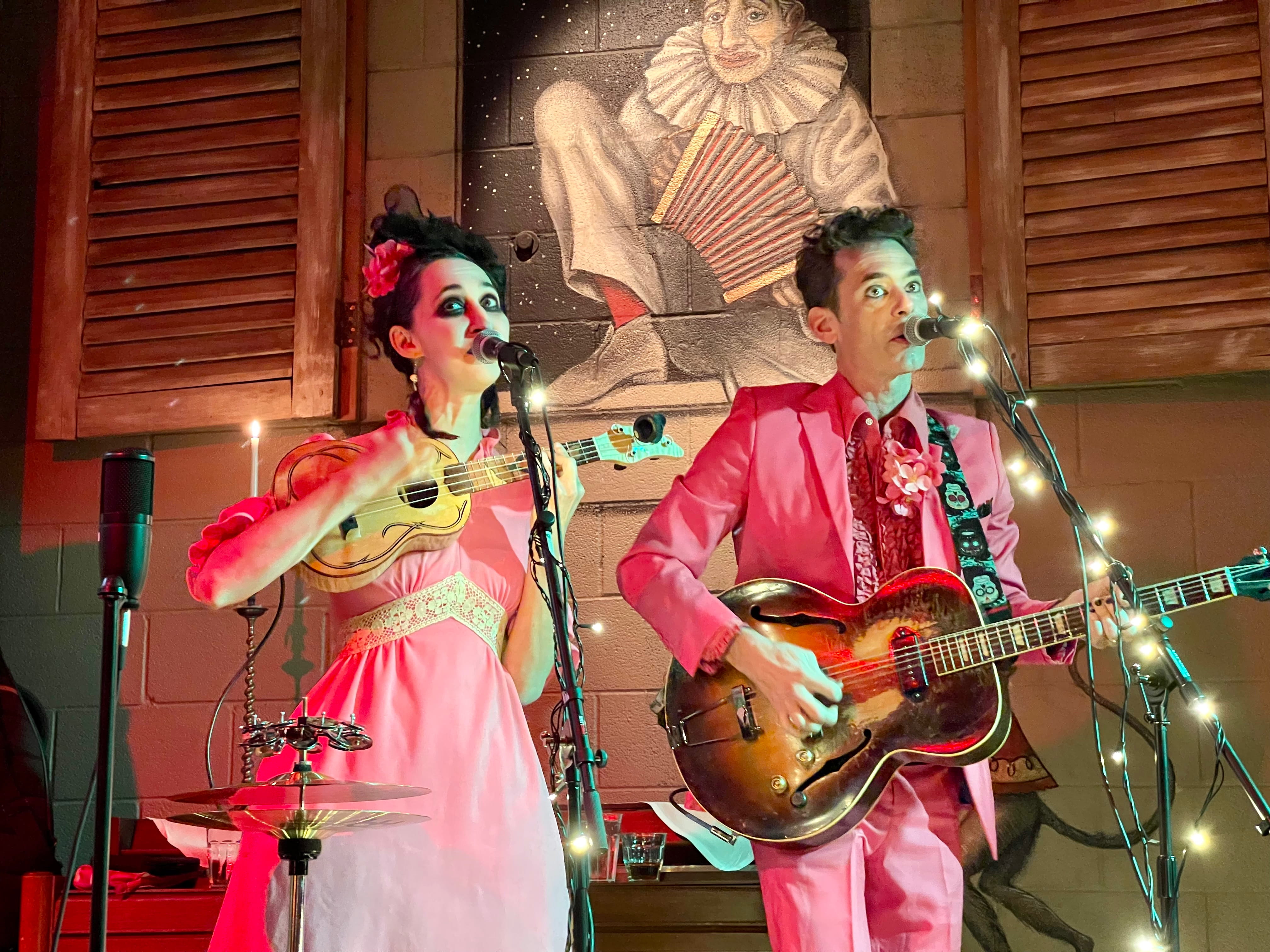 The Band Charming Disaster dressed in pink playing on The Pink Door Stage.