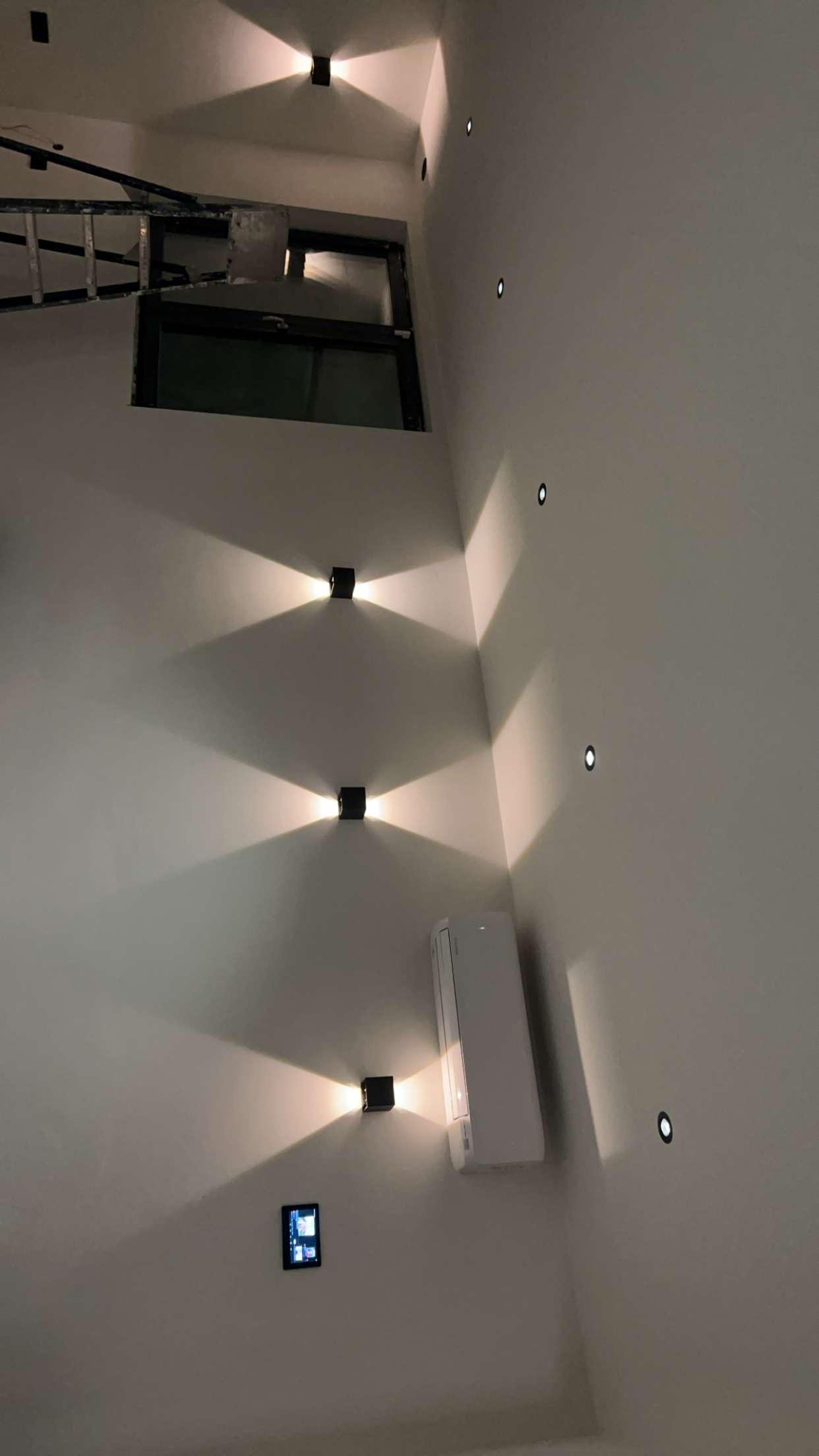 Modern glass building with illuminated interior and reflections at sunset