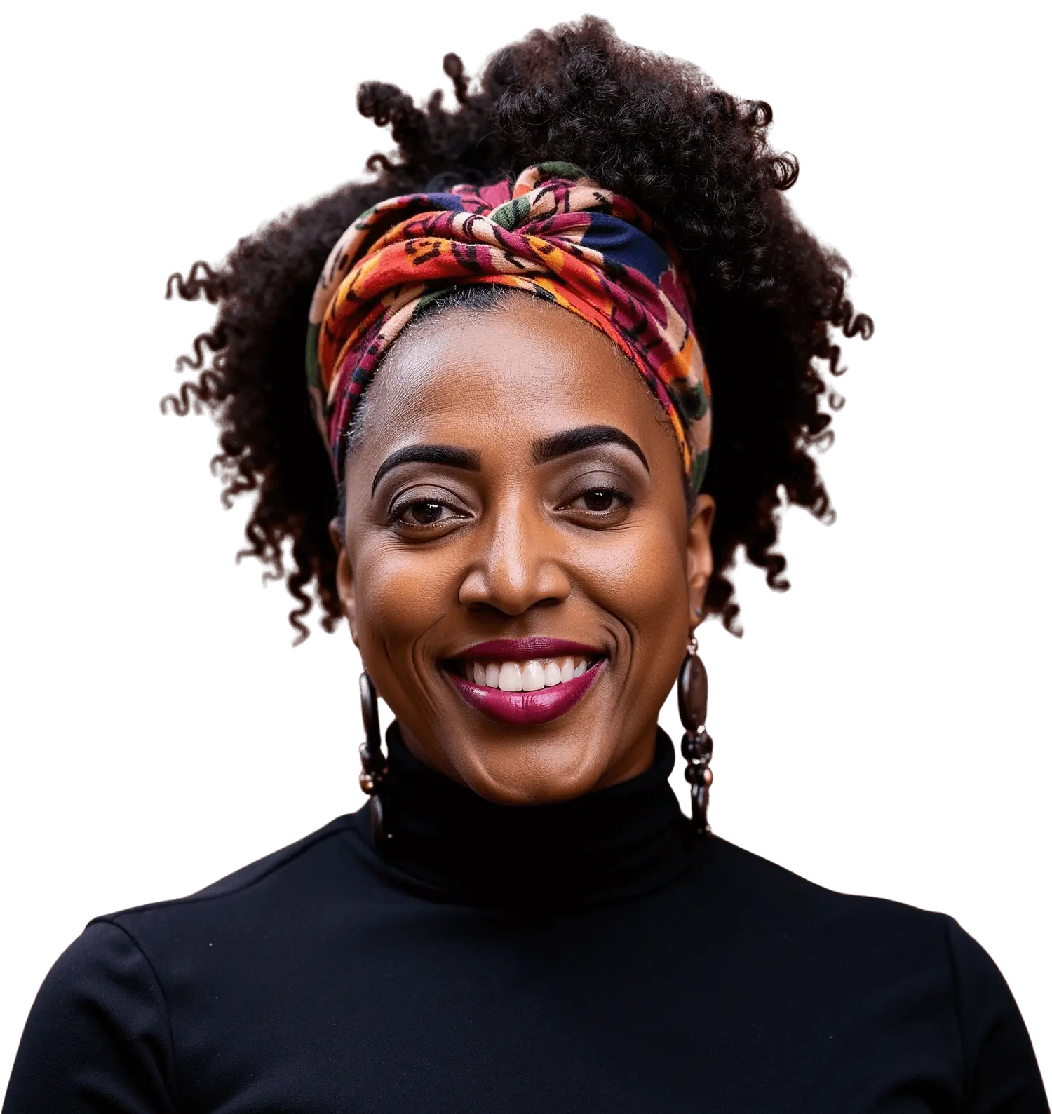 Smiling woman with colorful headwrap and earrings against black background.