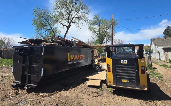 Truck unloading sand from dumpster