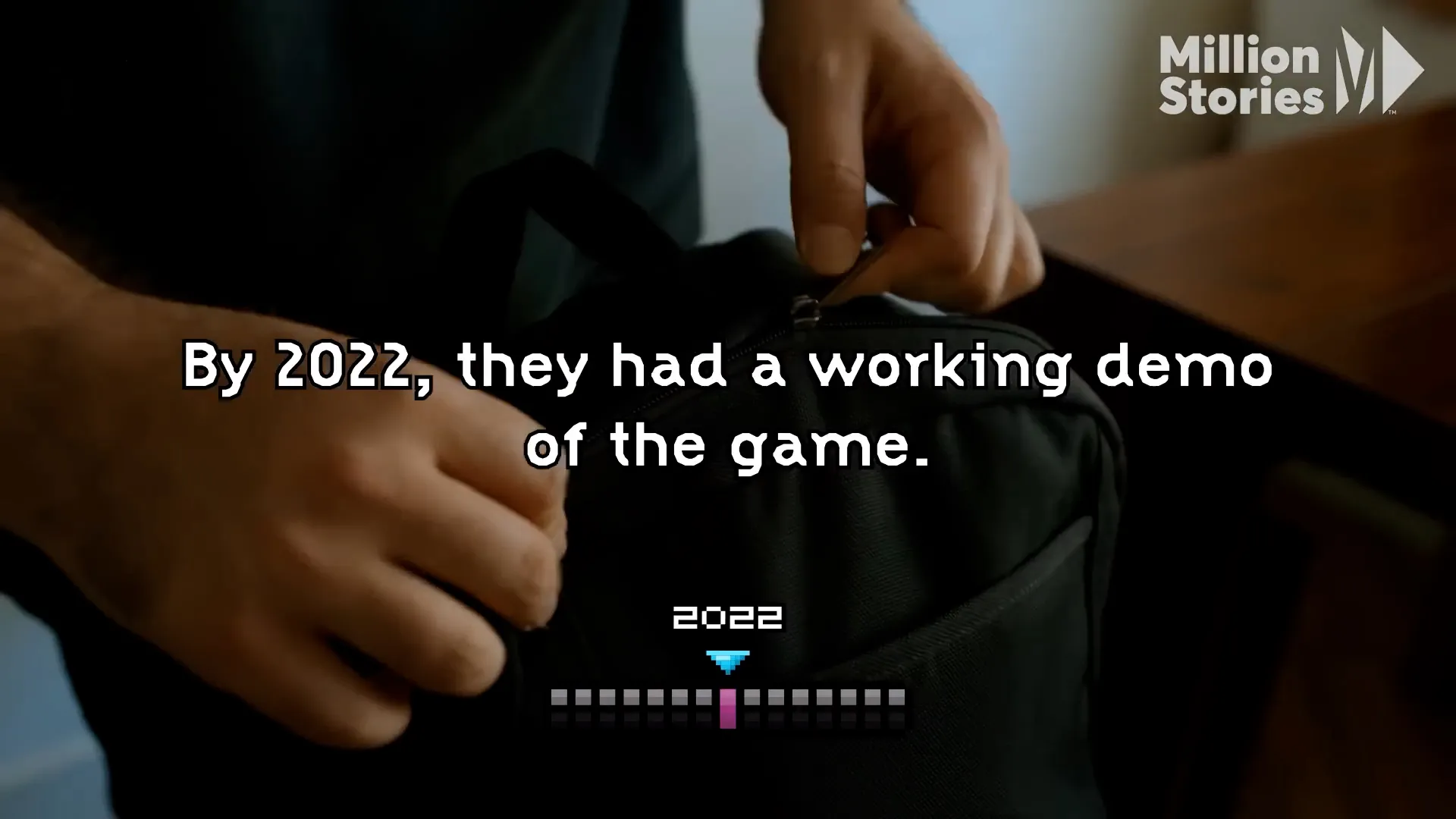 Close-up of hands opening a bag with on-screen text describing a 2022 game milestone