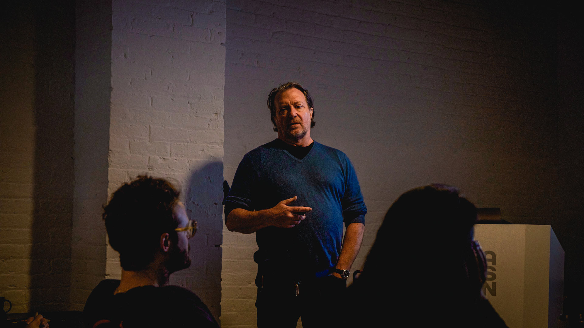 Ross MacDonald giving lecture in darkened classroom