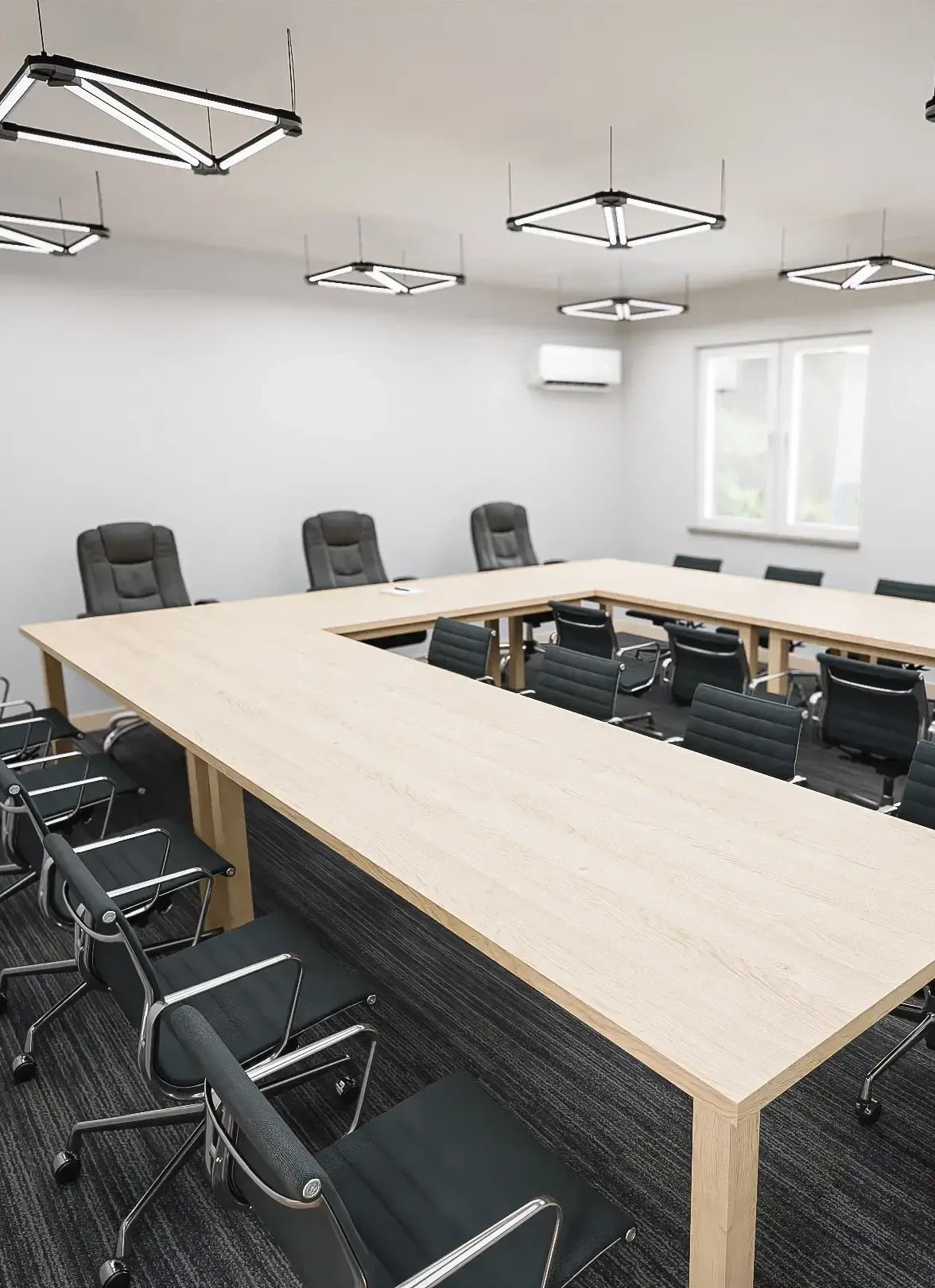Nowoczesna sala konferencyjna z dużym, jasnym stołem w kształcie litery U.