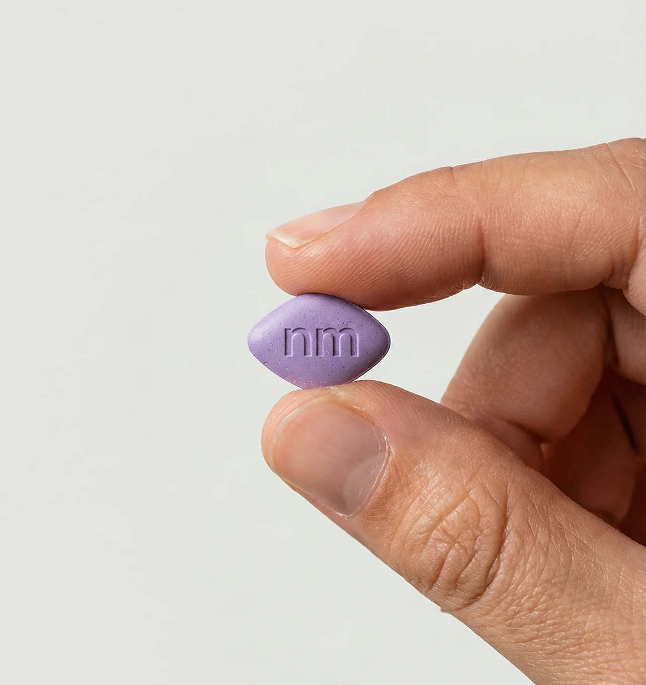 Hand holding a single Compounded Semaglutide tablet