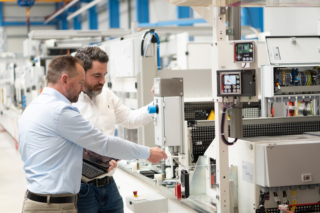 Ingenieure überprüfen Maschine in Fabrik. Qualitätskontrolle und Technik.