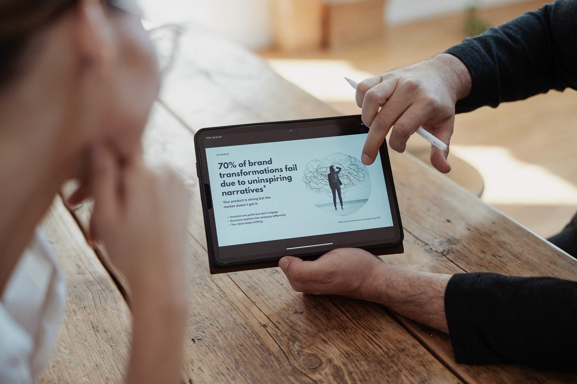 Consultant showing 70 percent of brand transformations fail due to unclear narratives on a tablet
