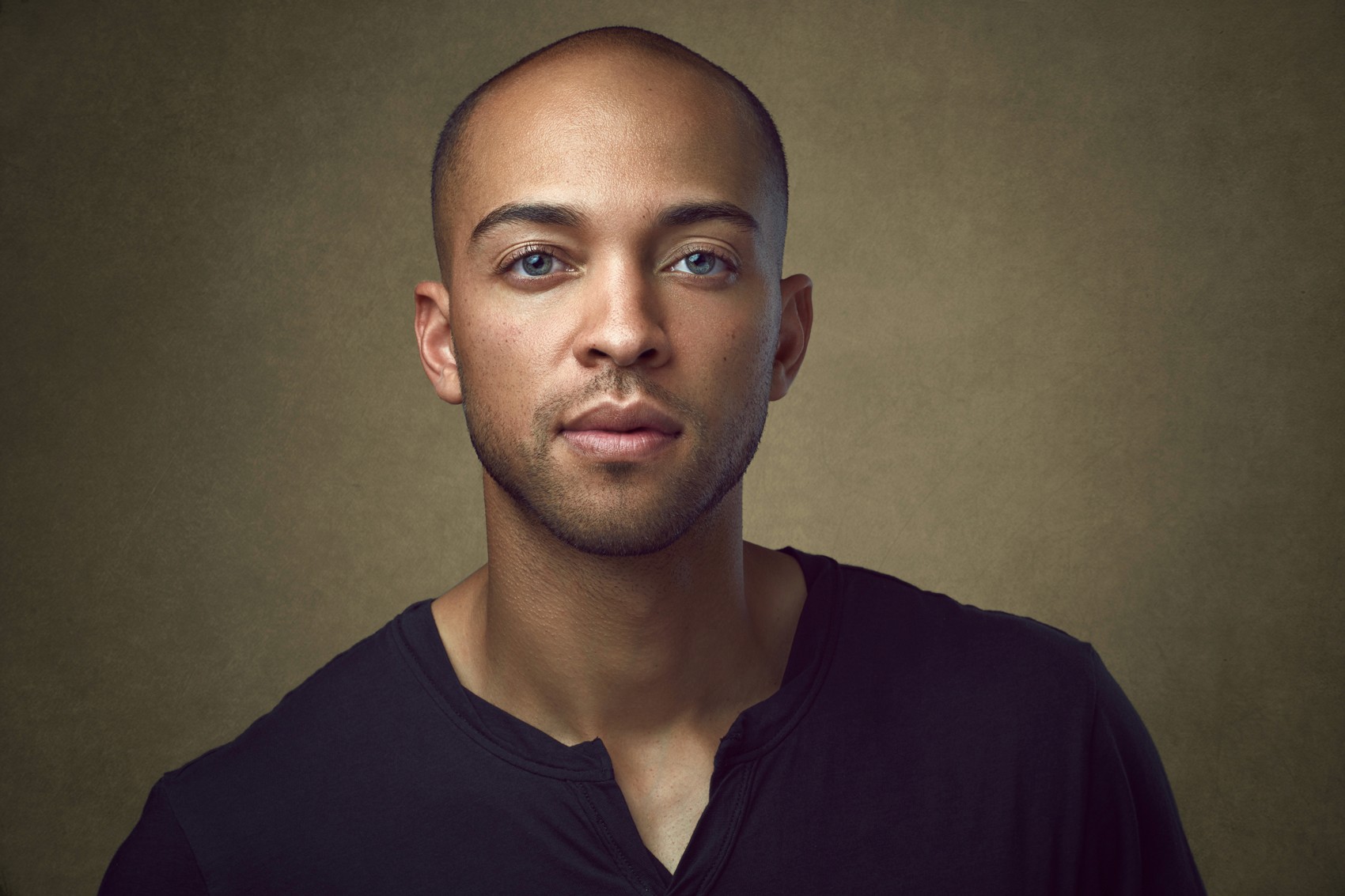 A confident tech founder headshot of a young handsome businessman in a business casual shirt, ensuring a standard of excellence for company online presense. Startup advisor headshots San Francisco.