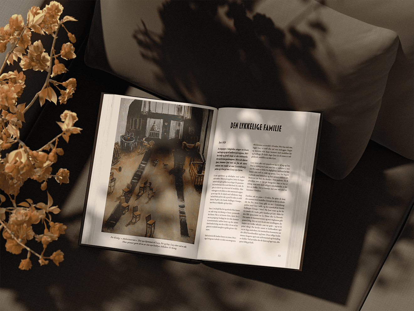 Otwarta książka „Den lykkelige familie” z ilustracją wnętrza i tekstem.