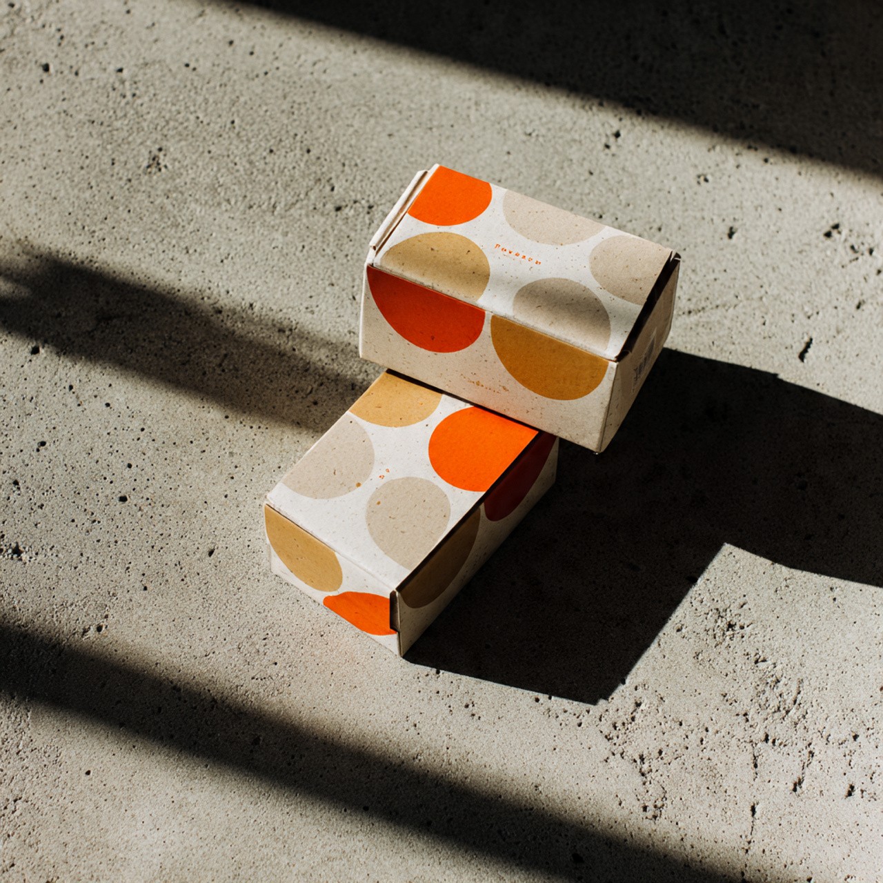 Two small cardboard boxes with a circular orange and beige pattern.
