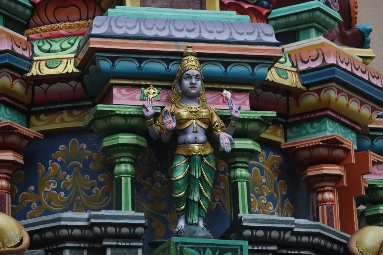een kleurrijk gedetaillerde clode-up van een regenboogkleurig beeld in een hindoe tempel