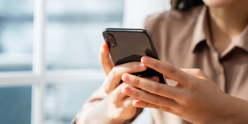 A woman using her phone to check her email