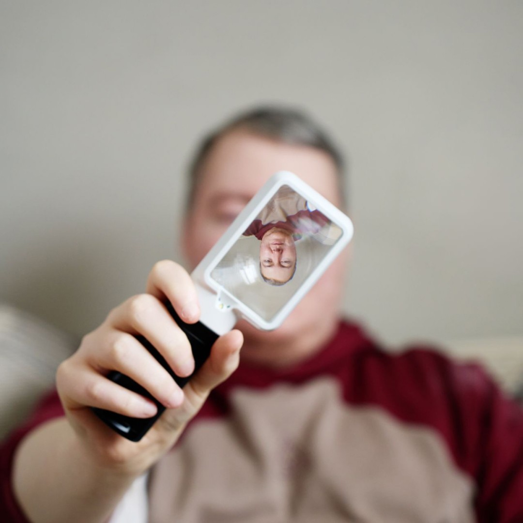 An image of Mark holding a magnifying tool in front of his face.
